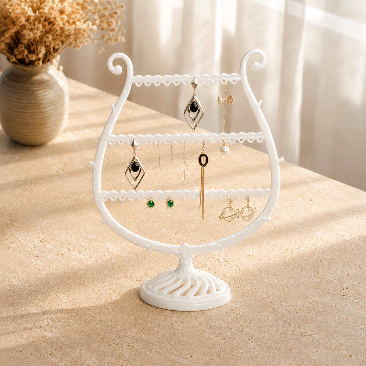 Présentoir À Boucles D’Oreilles Blanc Trois Niveaux presente en situation (Blanc) avec vase de fleurs sechees en arriere-plan